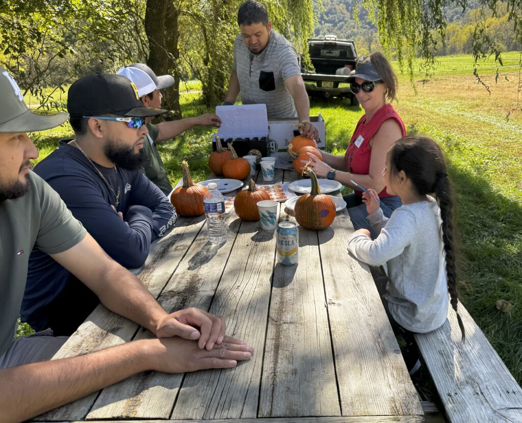 2025-0928 Kelly and team setting up the pumpkin painting table