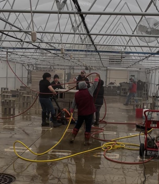 Crew working together to get the 'large' greenhouse ready for plants