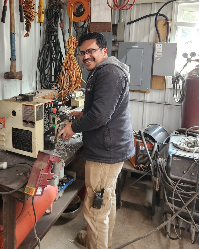 Miguel using lathe with a smile